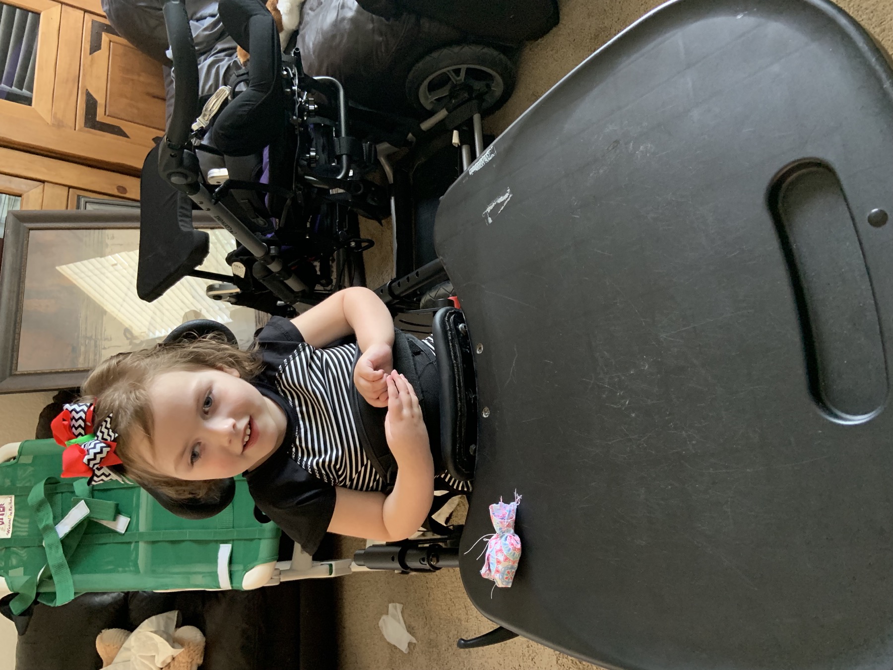 Sophia at home with her wheelchair and equipment nearby