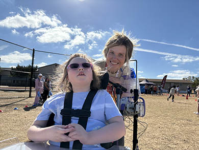 Sophia outdoors at a school event with her teacher