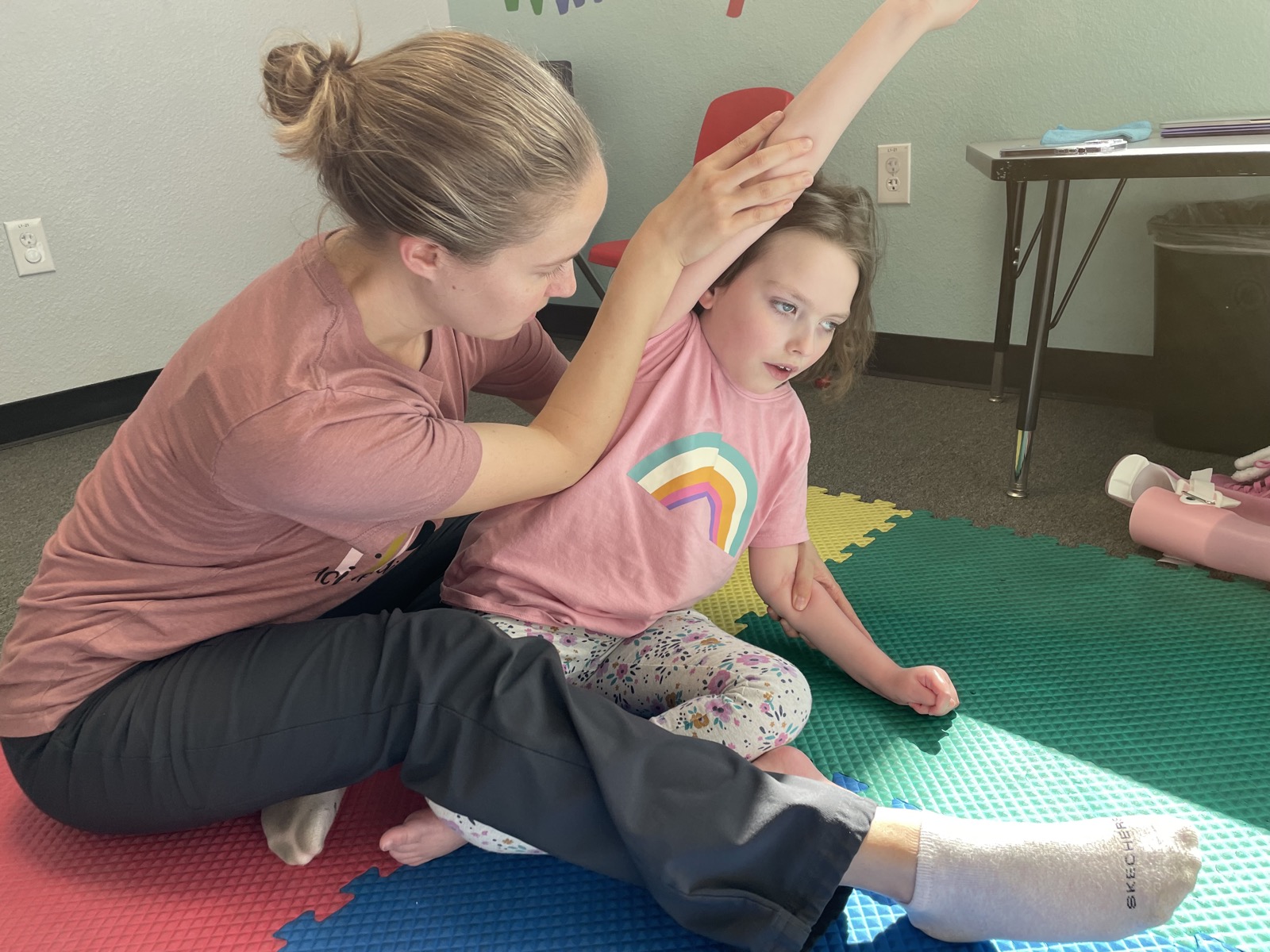 Sophia receiving physical therapy and stretching on the floor in 2022